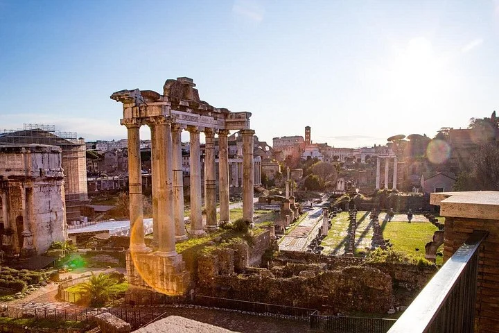 Temple columns and green Roman Forum ruins at sunset