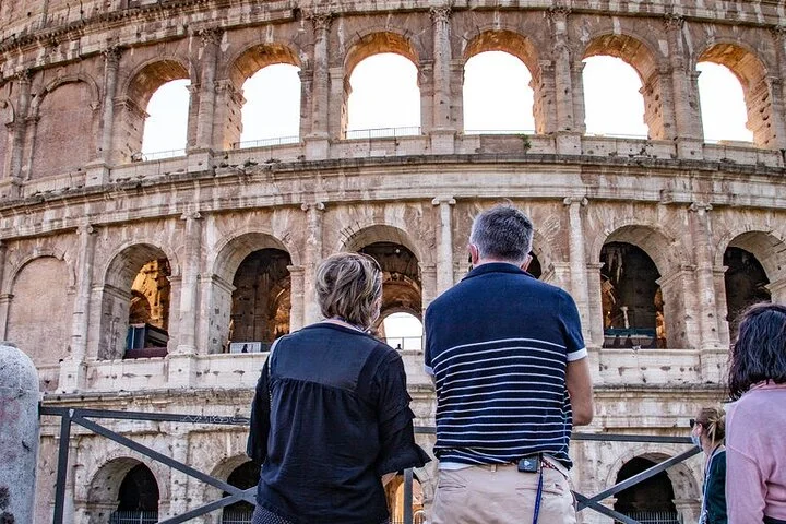 Visitors looking toward the Colosseum exterior from a public terrace