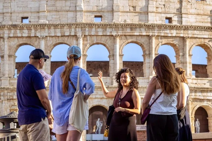 Guide speaking to visitors beside the Colosseum exterior