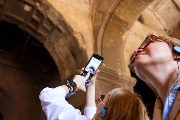 Visitors photographing the vaulted Colosseum masonry