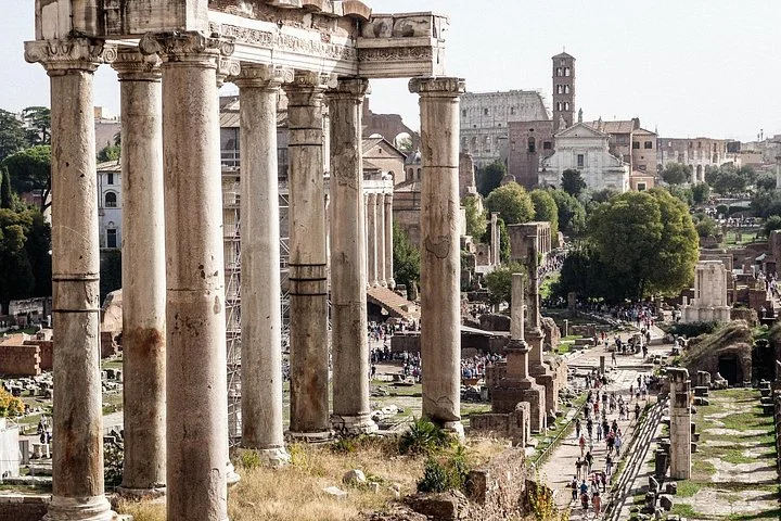 Tall Roman Forum columns with the Colosseum in the distance