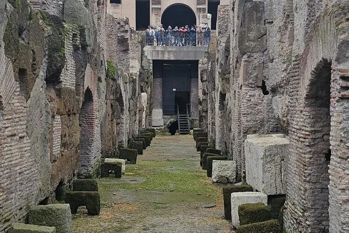 Stone walls line a passage through the Colosseum hypogeum.