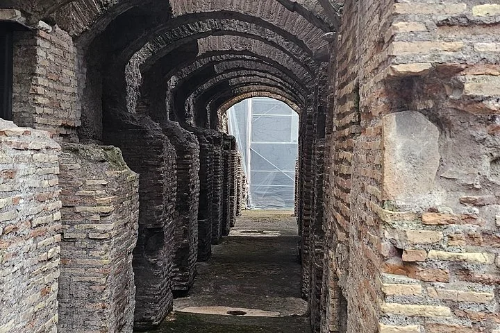 Brick arches recede along a narrow underground corridor.