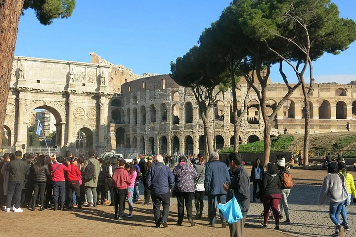 Visitors gathering near the Arch of Constantine with the Colosseum behind