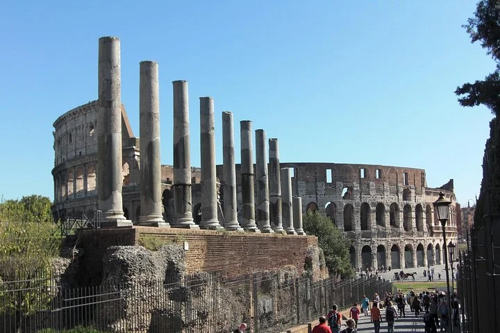 Colosseum exterior beyond ancient columns and a visitor path