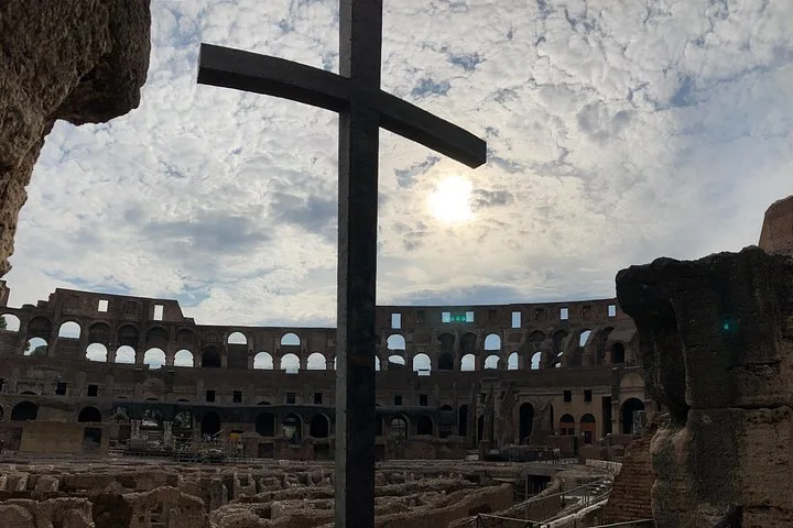 Cross silhouetted against the Colosseum interior