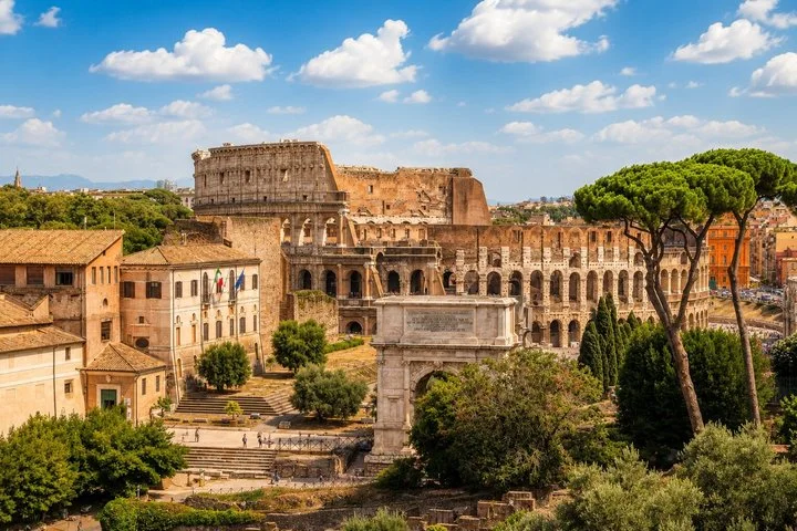 Colosseum and Arch of Titus beyond green Forum ruins