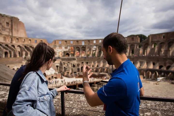 Guide and visitor at a main-level Colosseum overlook