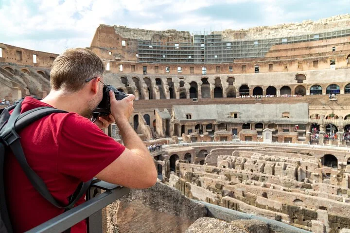 Visitor photographing the Colosseum interior from the main visitor levels