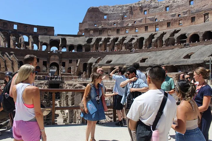 Visitors with a guide beside the Colosseum arena railing