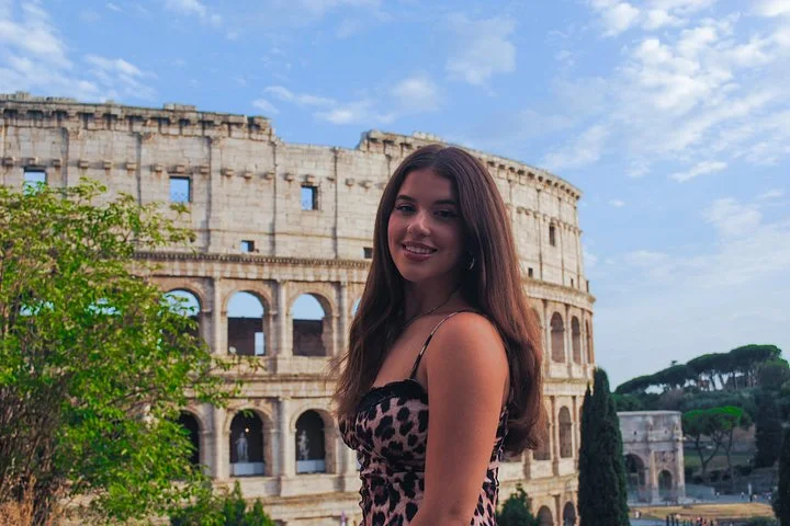 A portrait beside sunlit Colosseum arches