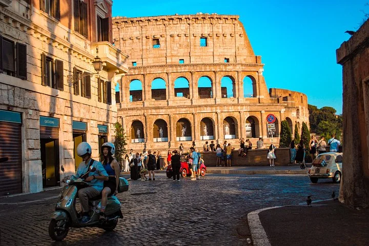 The Colosseum seen along a warm sunlit street