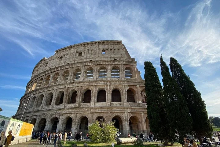 Colosseum exterior arches beneath a blue sky