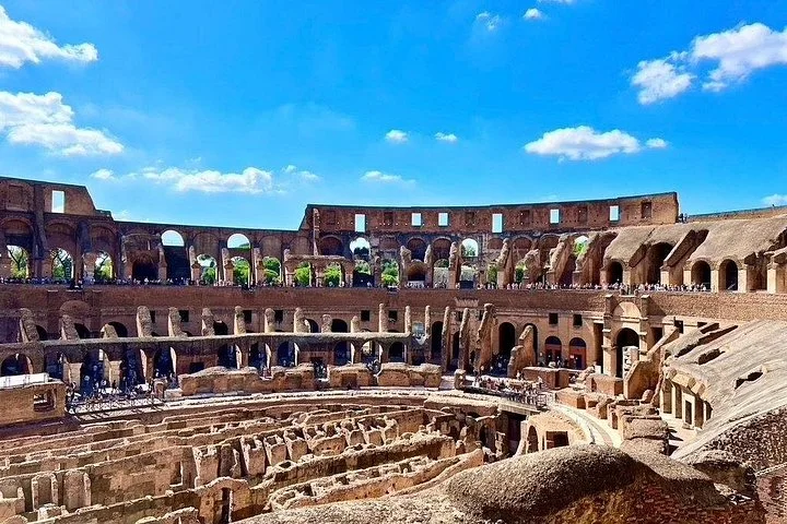 The Colosseum interior beneath a vivid blue sky