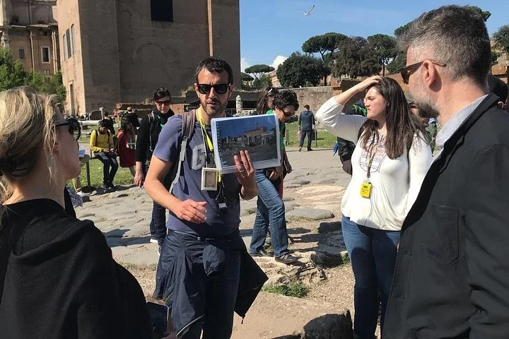 A guide explaining Roman ruins to visitors