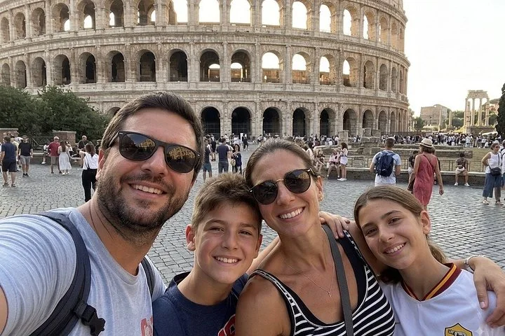 A family taking a selfie outside the Colosseum