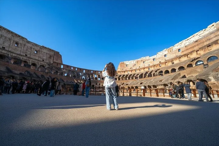 A visitor standing on the Colosseum arena floor