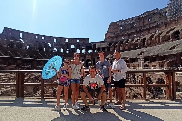 Visitors posing on the Colosseum arena floor