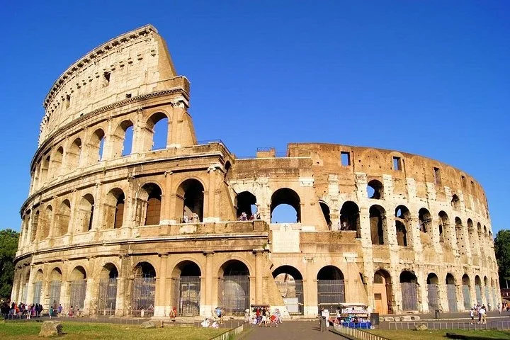 Sunlit Colosseum facade beneath a clear blue sky
