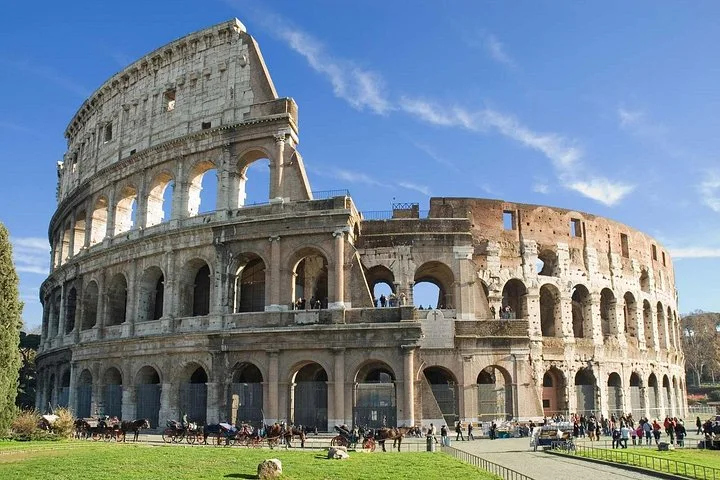 Colosseum arches beside a green lawn