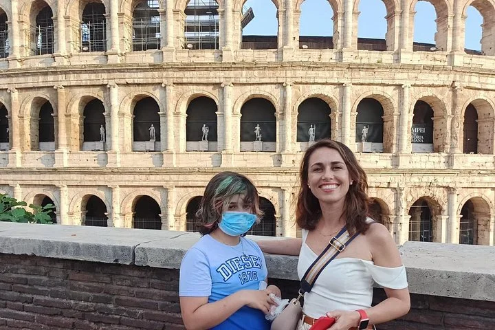Two visitors beside the Colosseum exterior