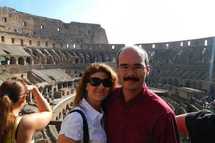 Visitors at a Colosseum interior viewing railing