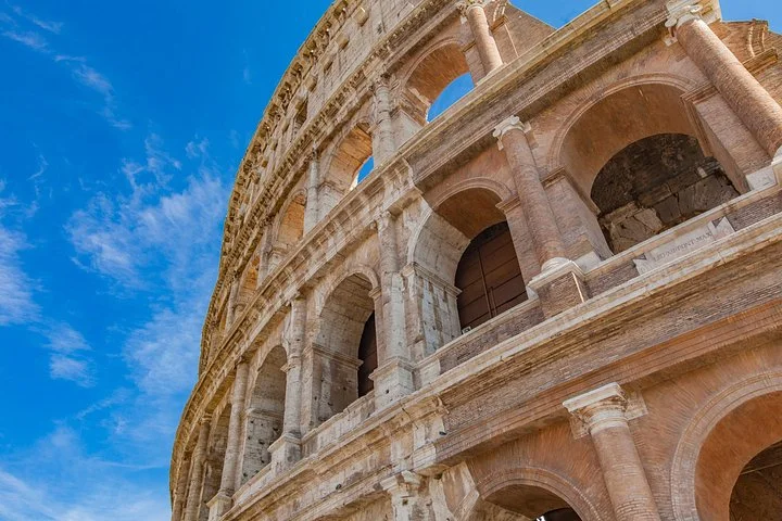 Looking up at the Colosseum’s stone arches