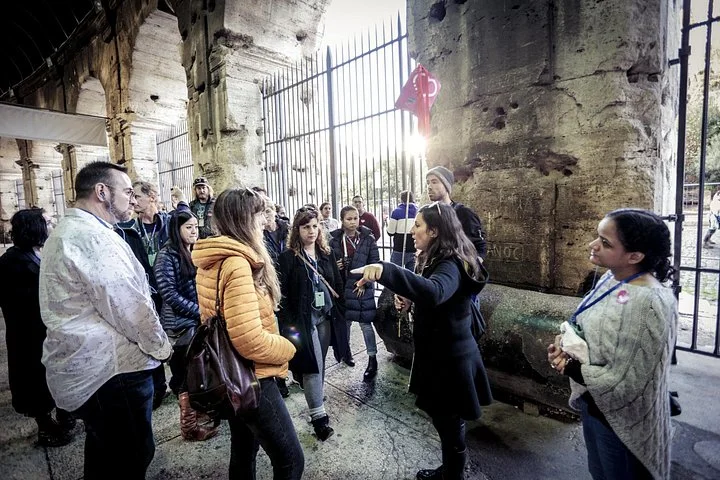 A guide speaking beneath Colosseum arches