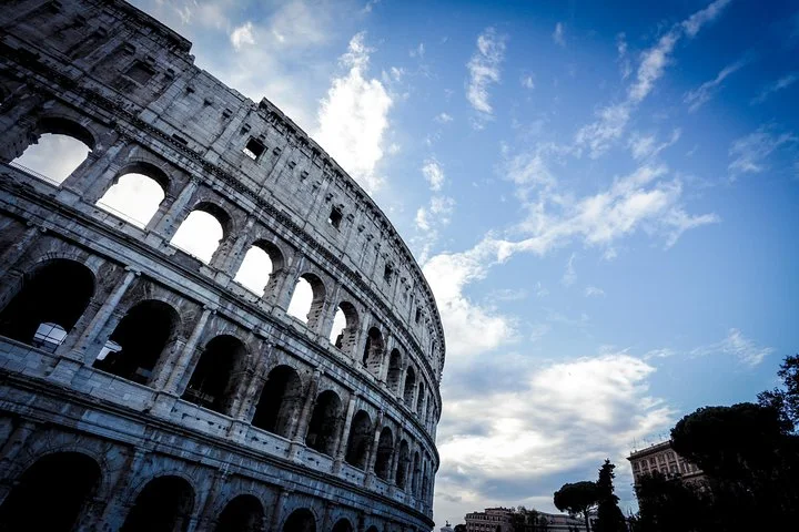 Colosseum facade beneath streaked clouds