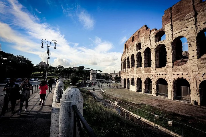 Visitors walking beside the Colosseum exterior