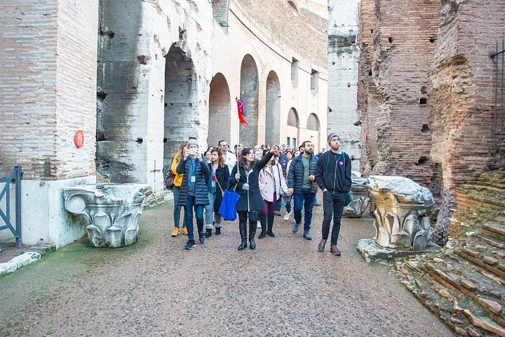 A guided group walking through a Colosseum arcade