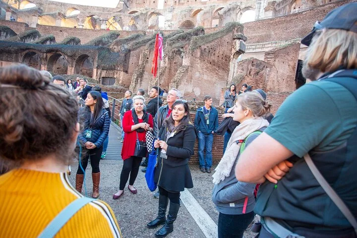 A guide addressing visitors inside the Colosseum