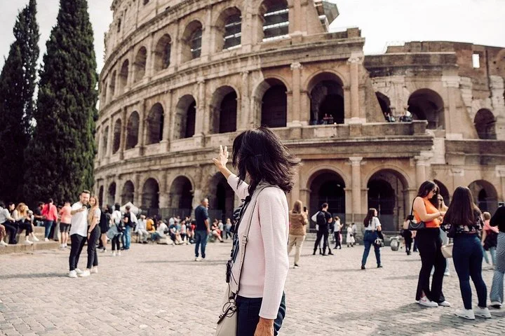A guide gesturing beside the Colosseum facade