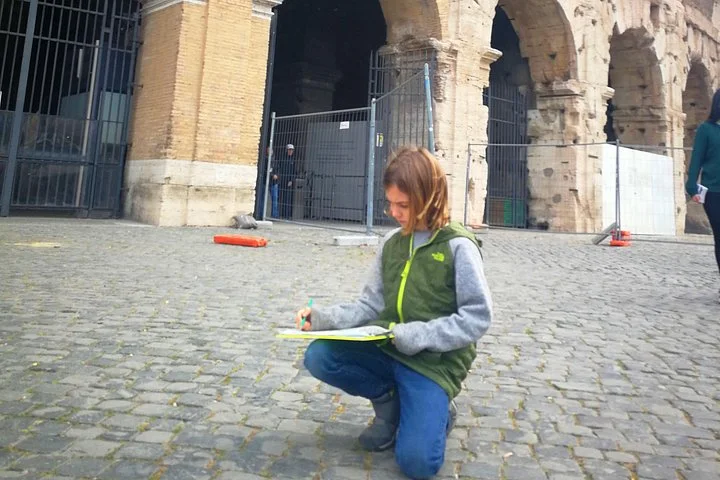 A child working on an activity sheet outside the Colosseum