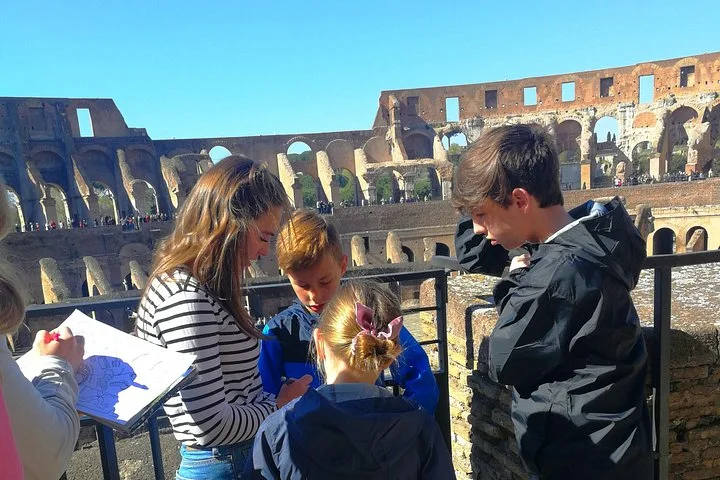 Children and a guide looking at activity pages inside the Colosseum