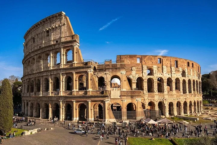The Colosseum exterior under a deep blue sky