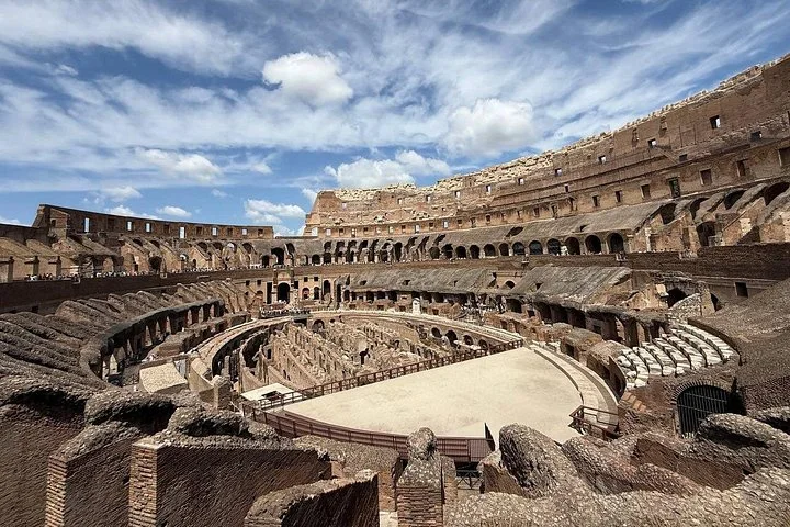 The Colosseum interior beneath dramatic clouds