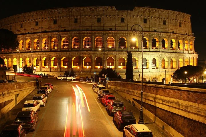 Night traffic beside the illuminated Colosseum