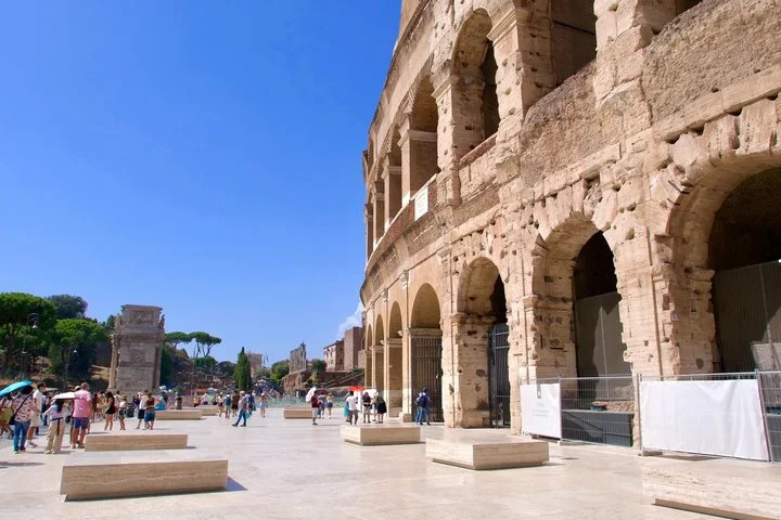 The Colosseum's sunlit outer arches overlook the plaza.