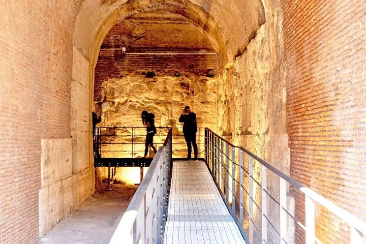 An illuminated passage leads between ancient brick and stone walls.