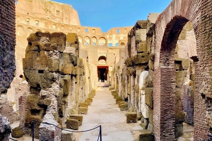 A narrow passage runs between the Colosseum's underground stone walls.
