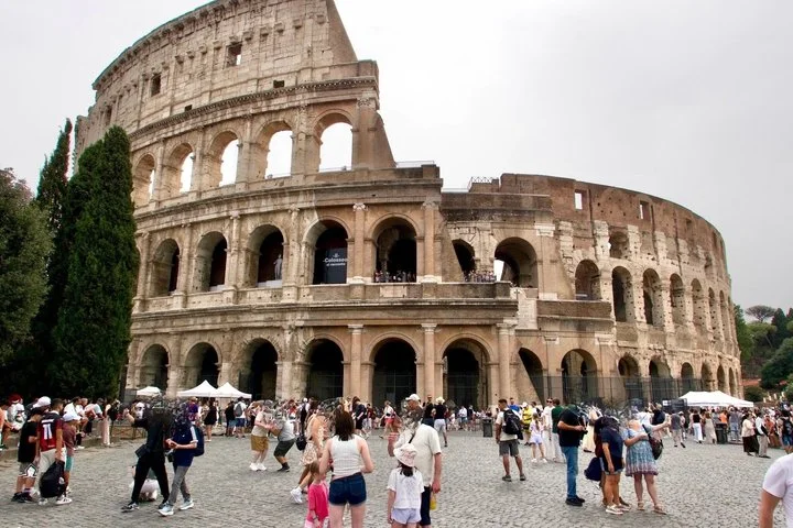 Travellers walking toward the Colosseum facade