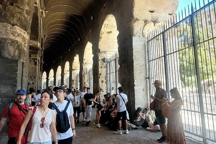 Visitors in a shaded Colosseum arcade