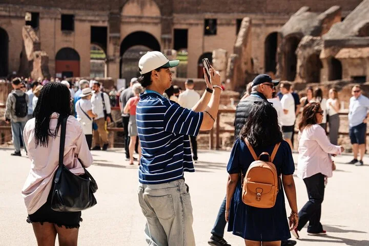 Visitors photographing the Colosseum from the arena