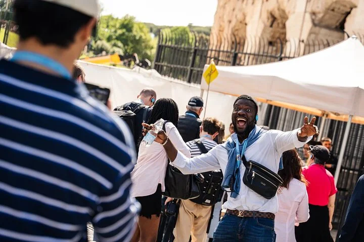 A guide greeting visitors outside the Colosseum