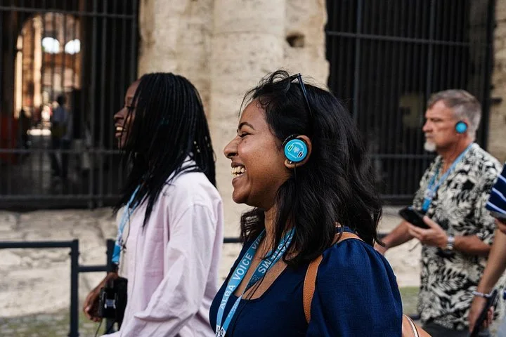 Visitors listening with headsets inside the Colosseum