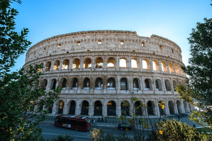 The Colosseum facade framed by green trees
