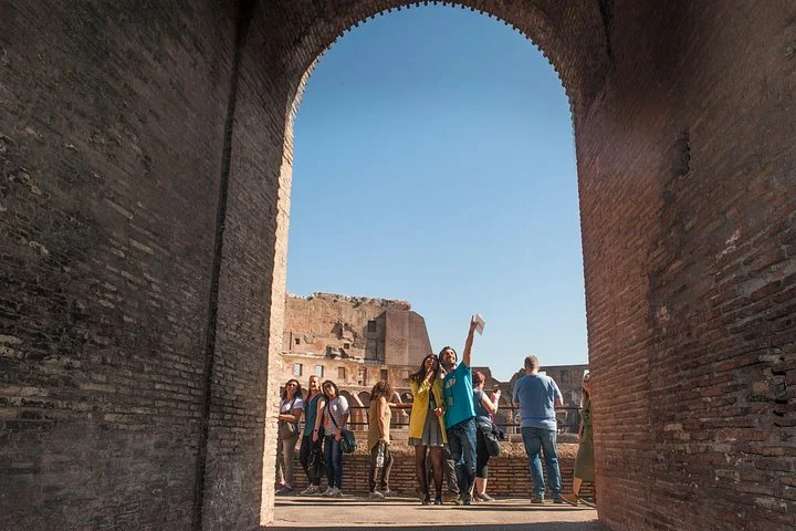 Visitors beneath the arch leading toward the arena
