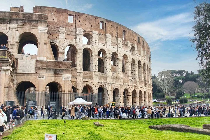 The Colosseum facade beside a green lawn