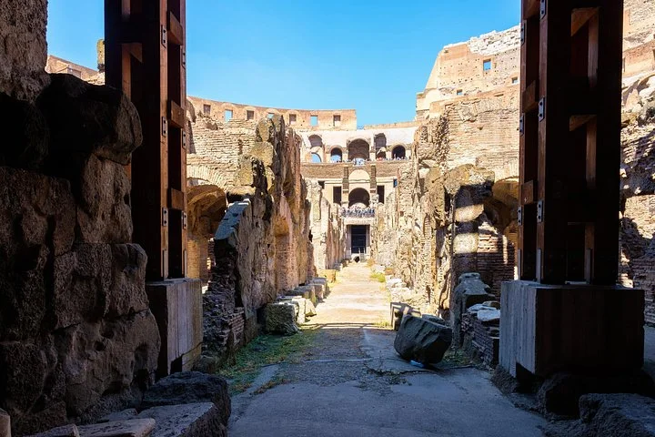 Stone passages and timber structures beneath the Colosseum arena.